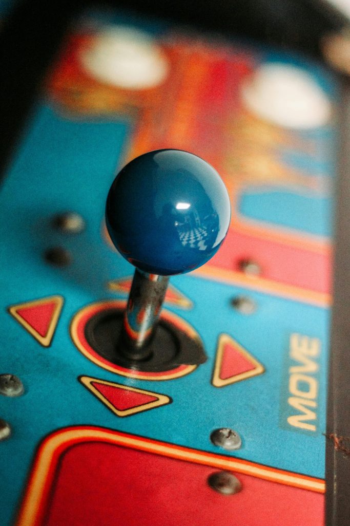 Close-up of a vibrant retro arcade joystick showcasing vintage gaming aesthetics with colorful design.